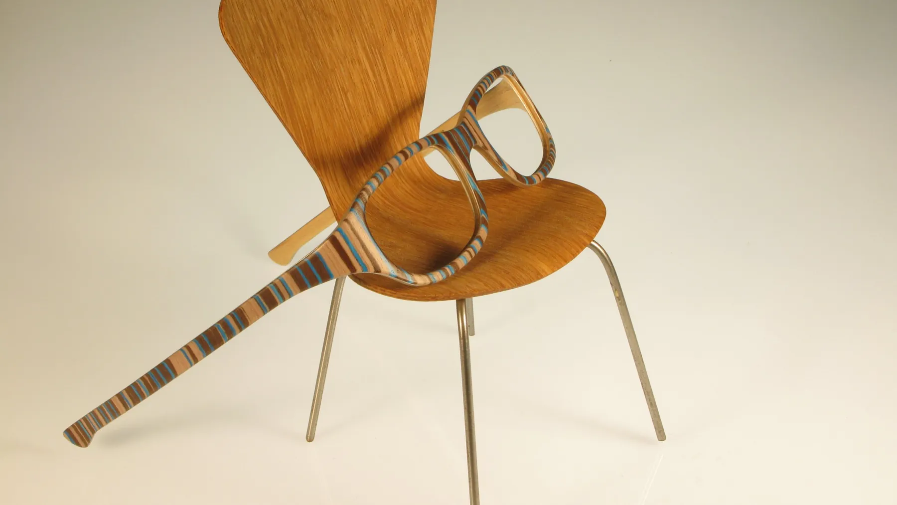 W-eye, bois rayé de bleu, sur une chaise de designer